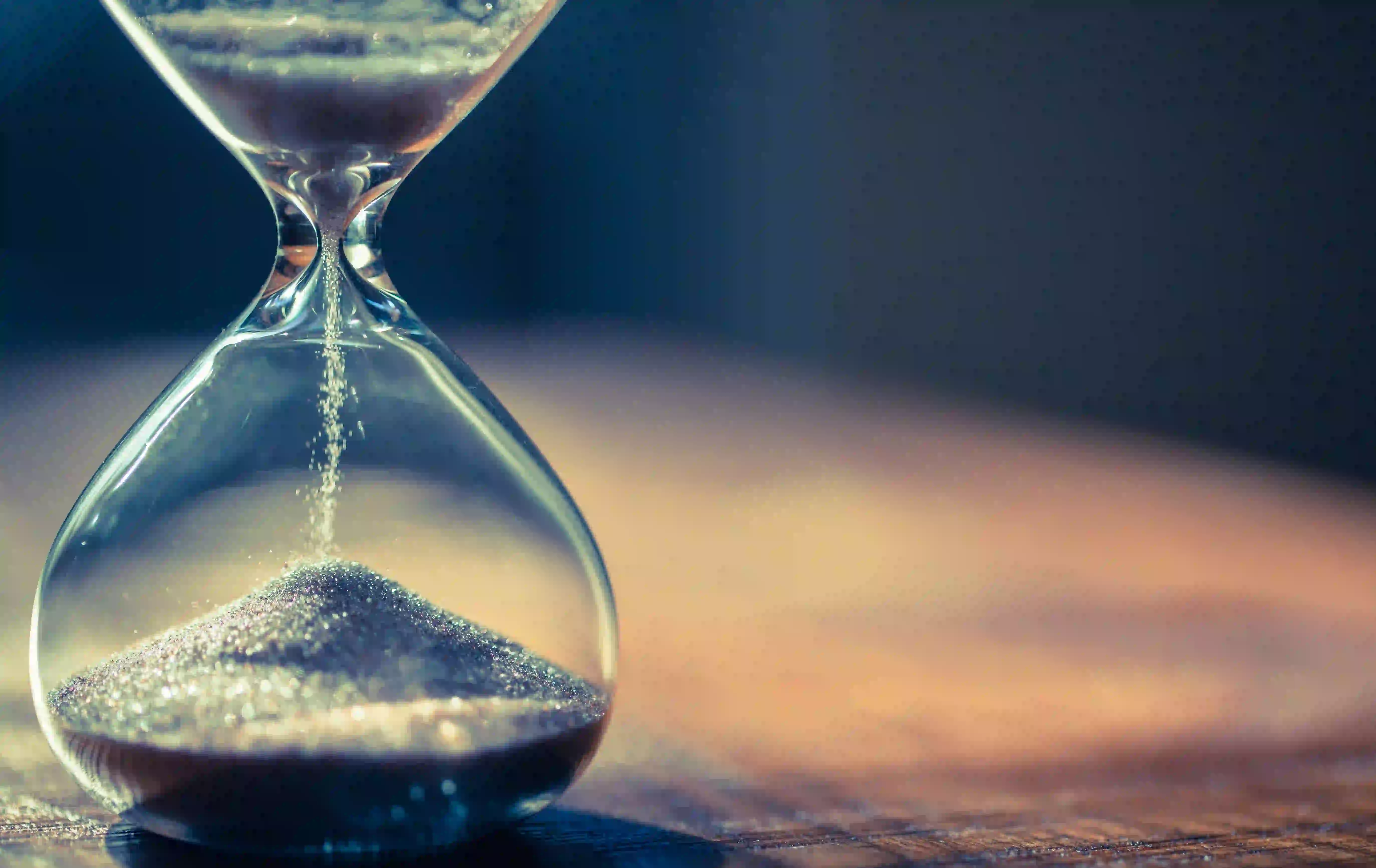 sand running in an hourglass that measures time passing sand running in an hourglass that measures time passing